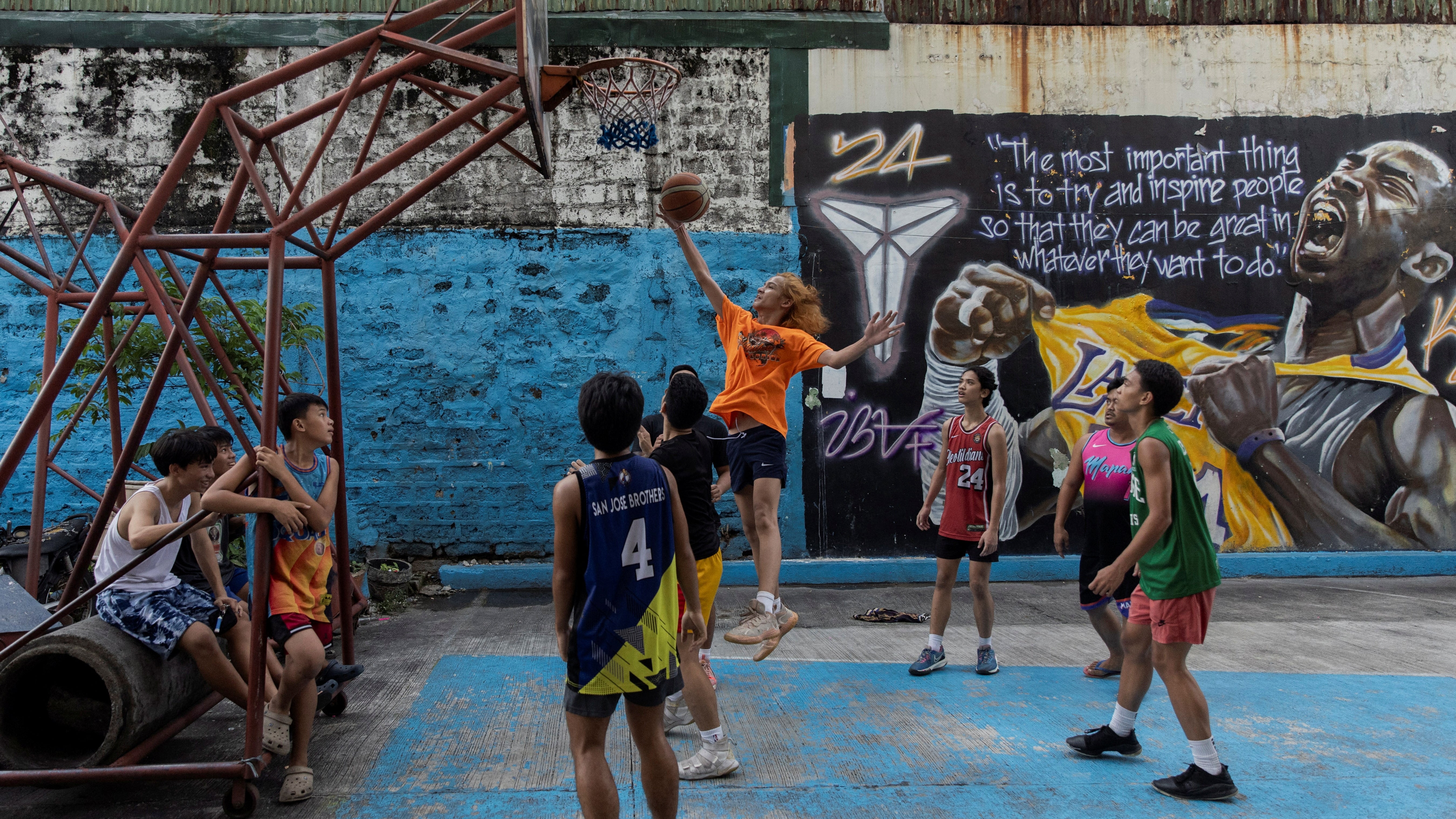 Outdoor street basketball court in the Philippines with young players during a game