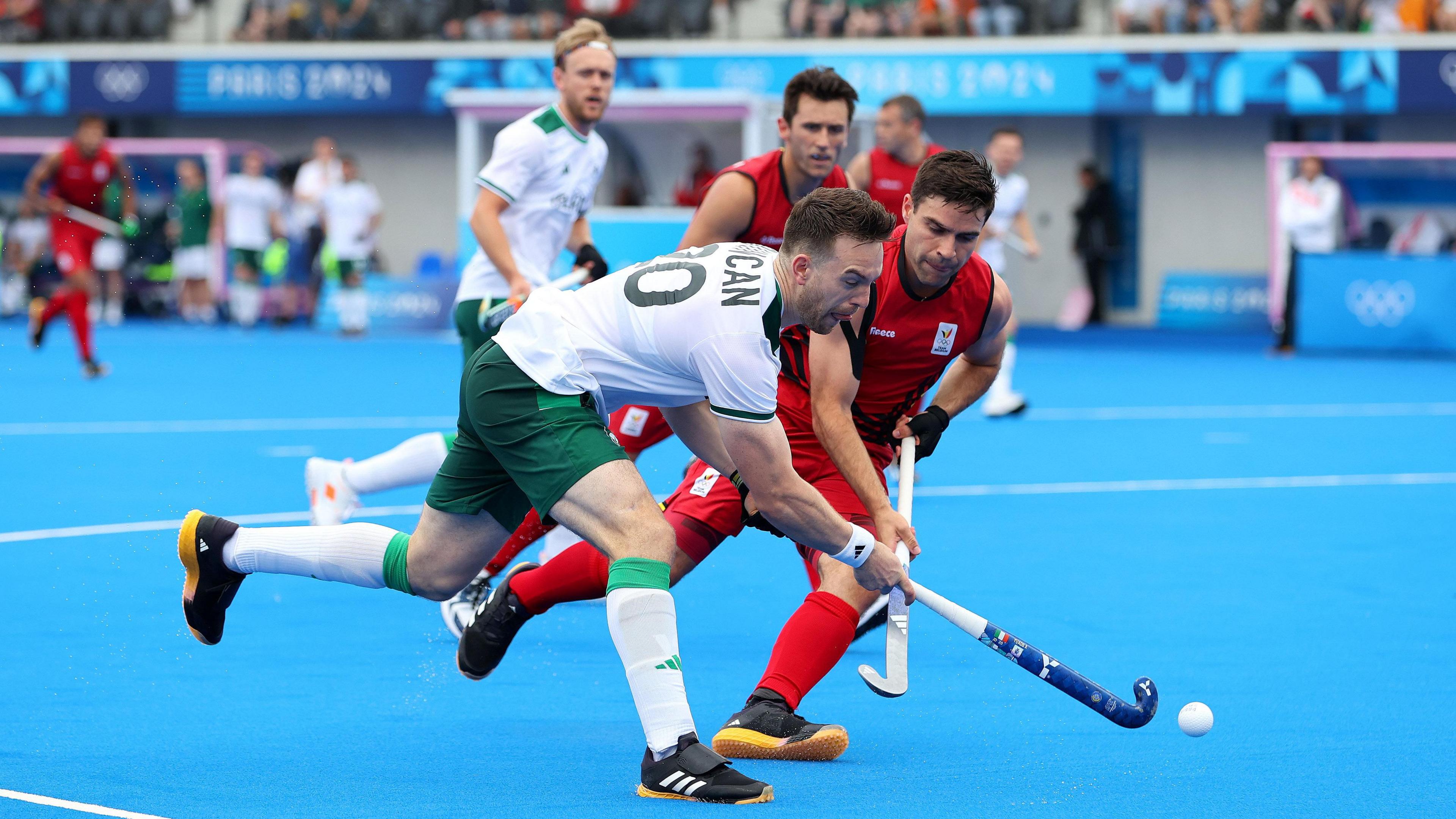 Two opposing field hockey players battling for the ball during an elite international match