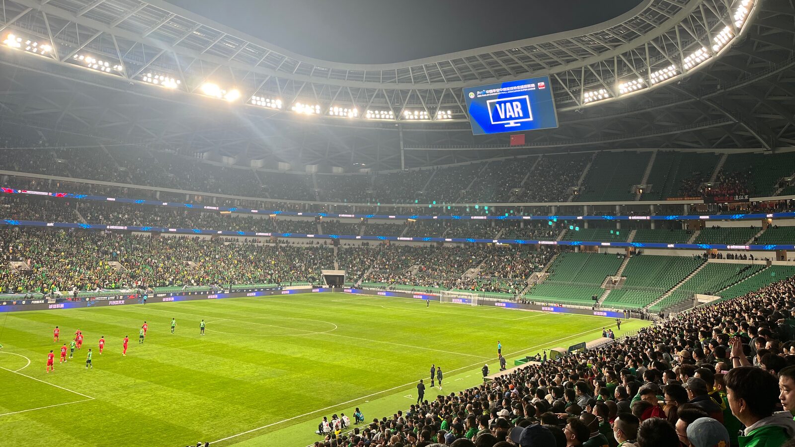 Modern Chinese football stadium with a large crowd during a match