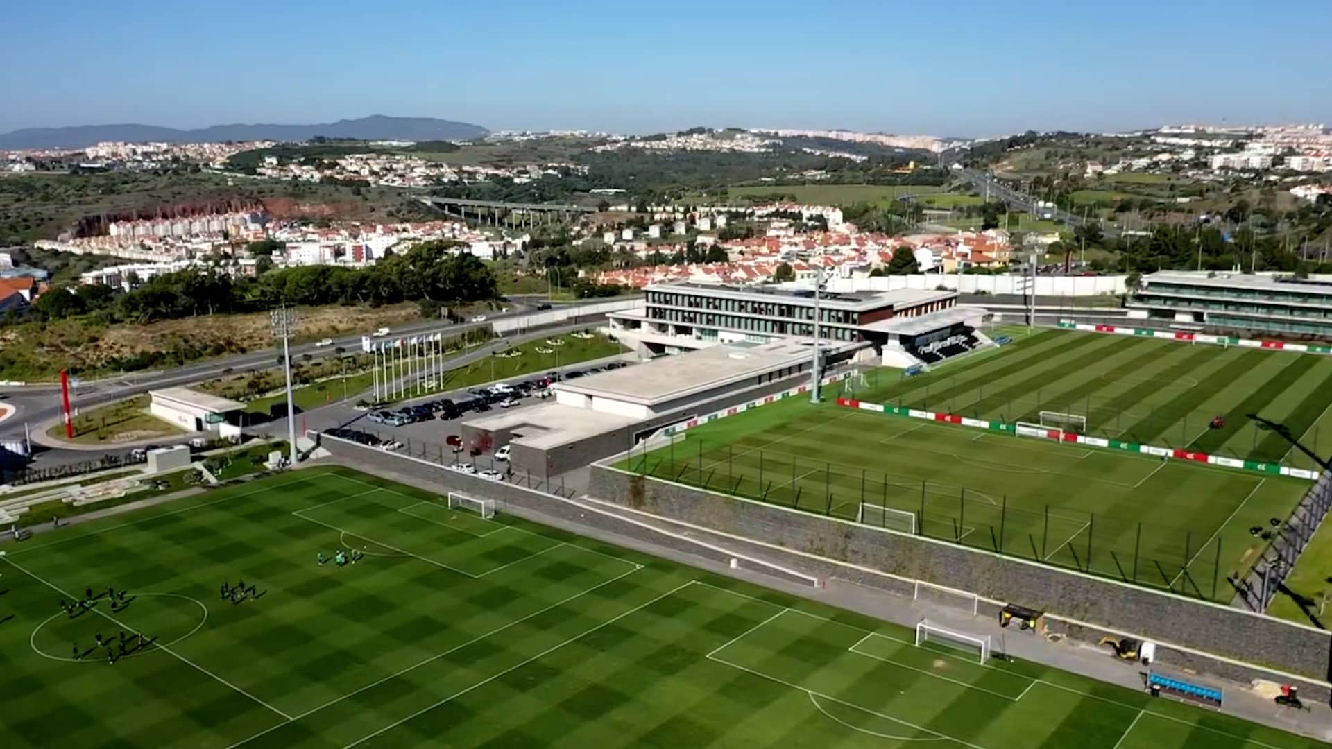 Professional Portuguese football training facility with multiple pristine grass pitches