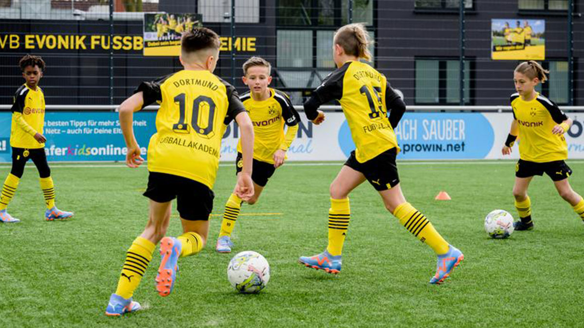 Youth footballers training at a European club academy facility during a football trip to Europe