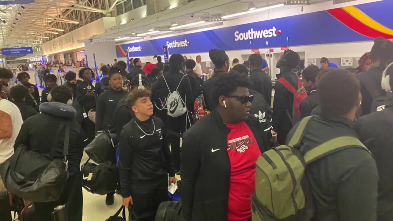 A youth football team travelling together on an international sports tour with their kit bags