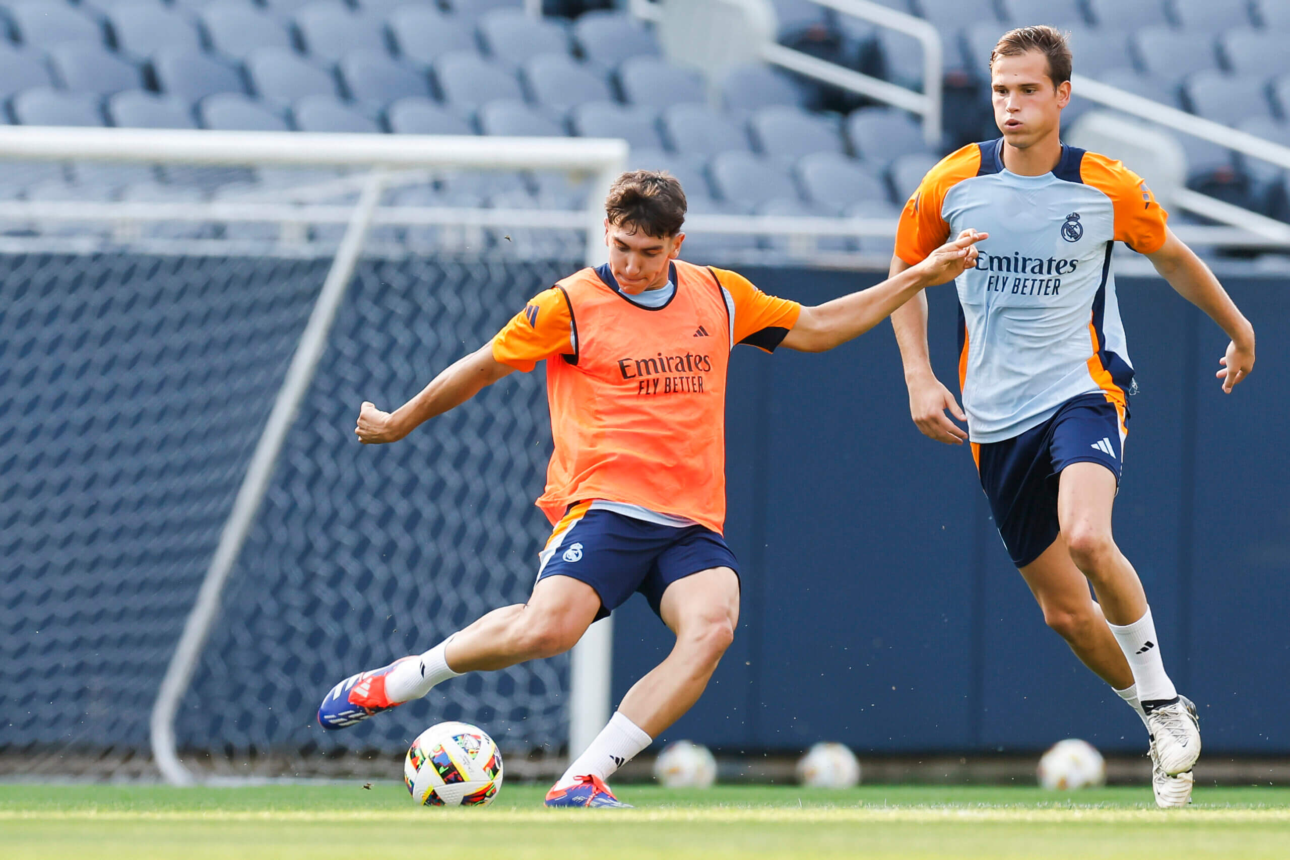 Professional football players in branded training kits during an elite pre-season training session on a stadium pitch