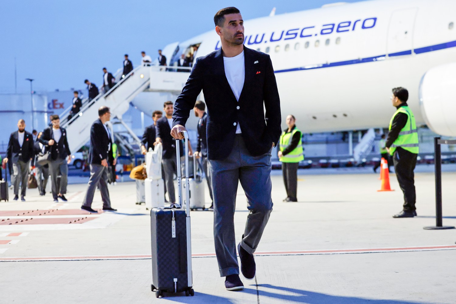 Elite football squad walking together through an international airport at the start of an overseas tour