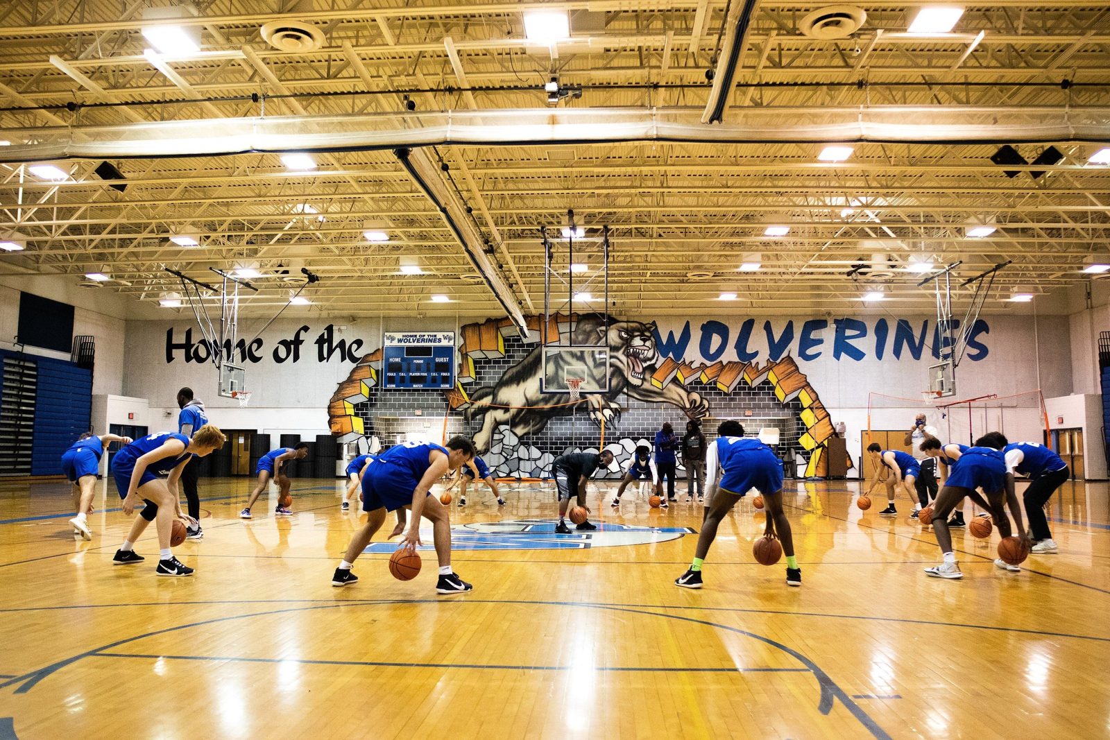 High-school basketball team running a ball-handling drill during training.