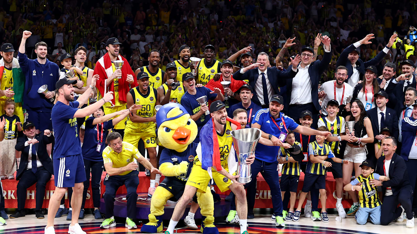 Professional basketball players competing in a packed European arena