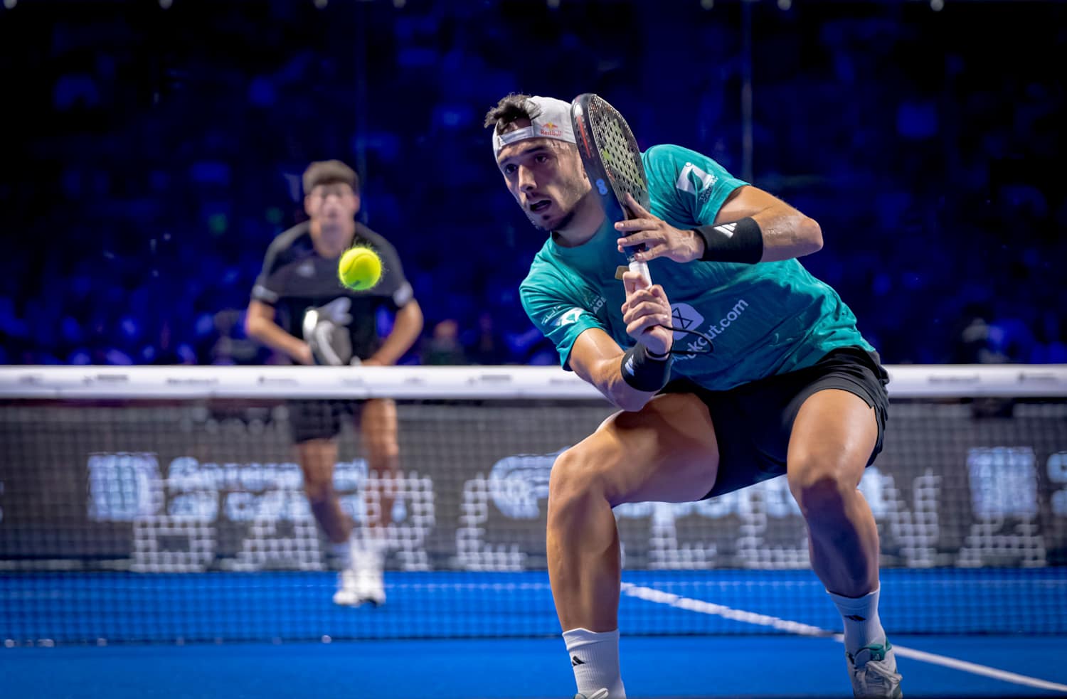 Padel team celebrating on glass-walled court during international padel tour