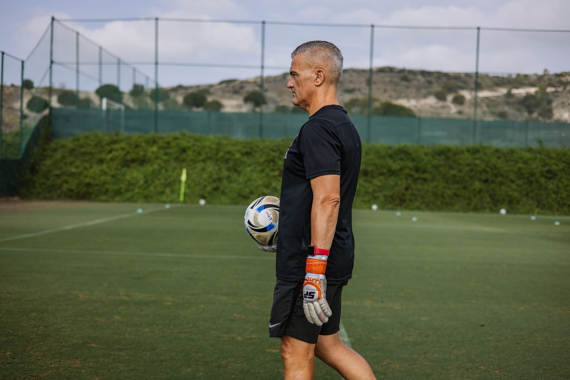 Professional football coach with a ball on a well-kept training pitch in southern Europe