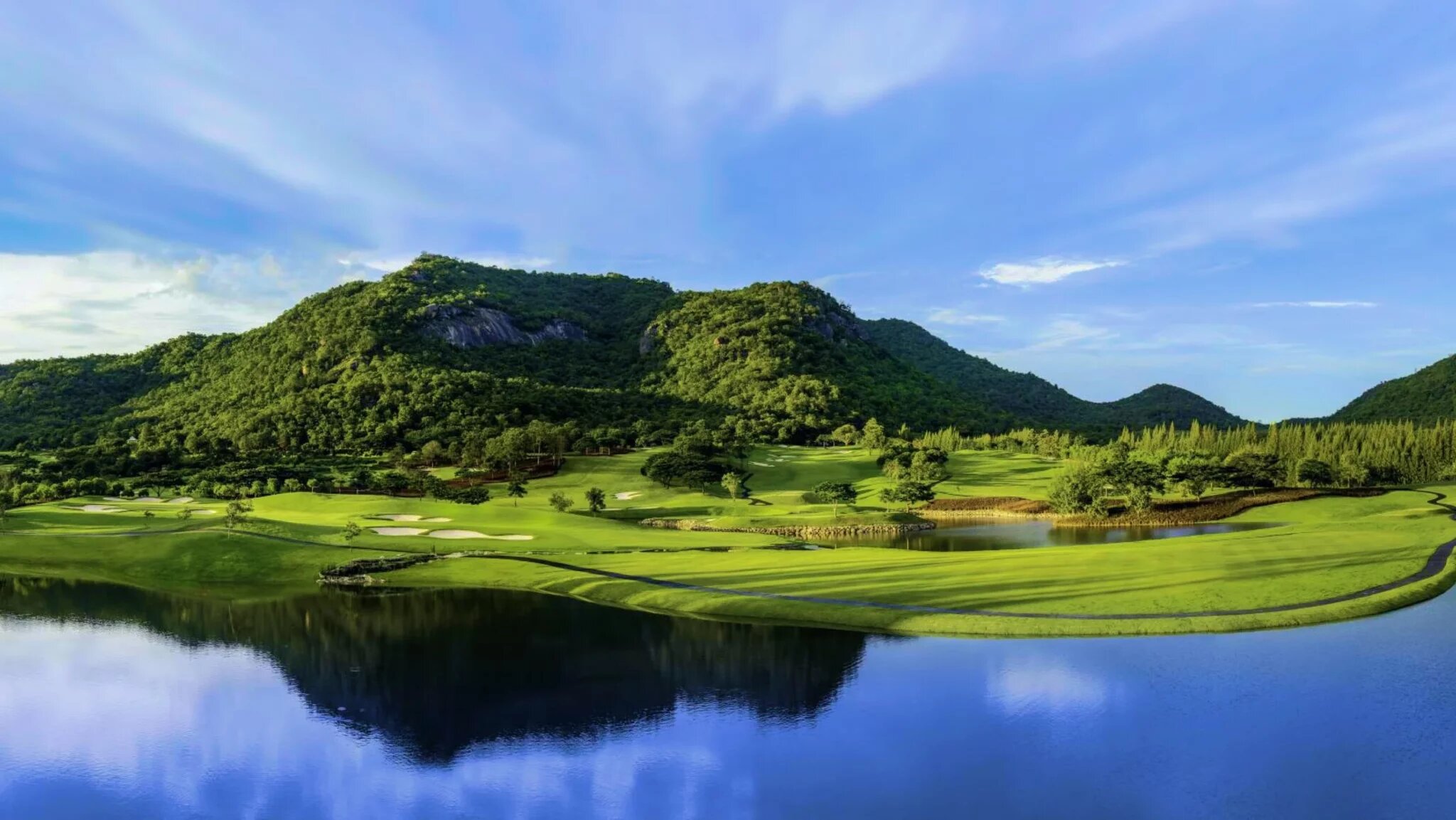 Championship golf course in Thailand with tropical mountains behind manicured fairways