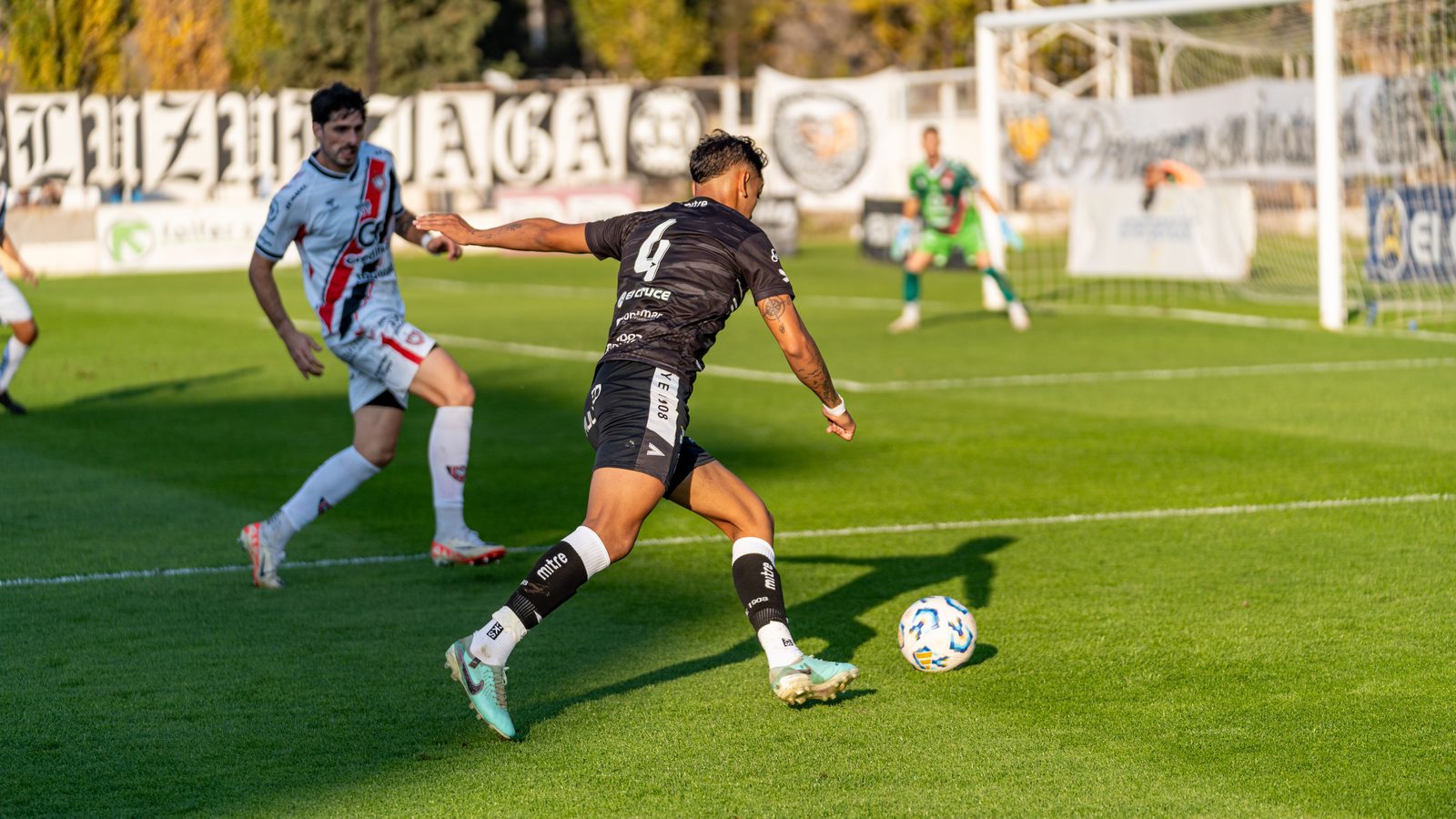 Professional footballer striking the ball during a competitive league match