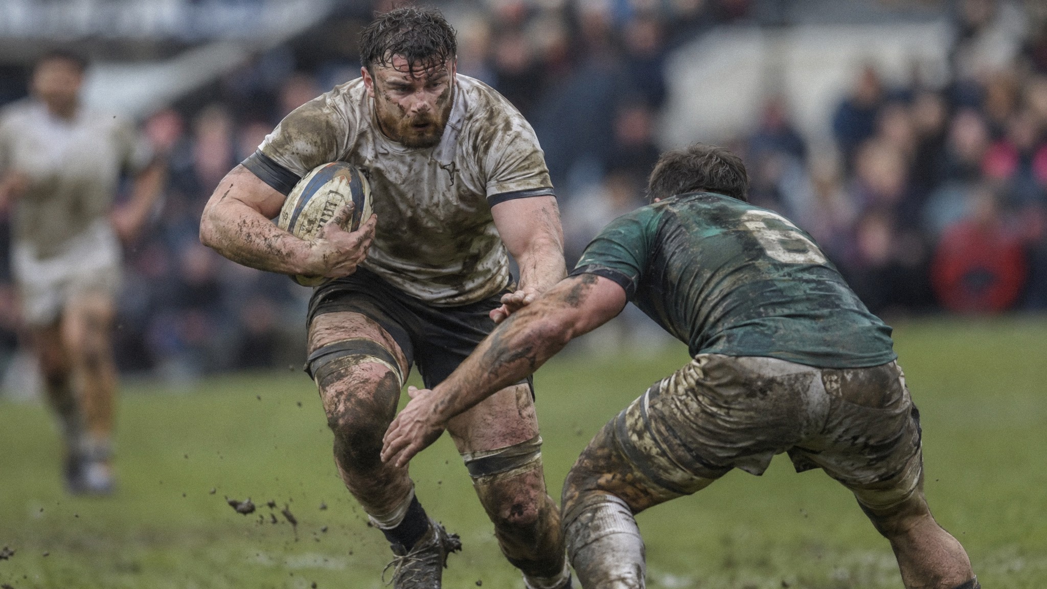 Professional rugby player carrying the ball into a tackle