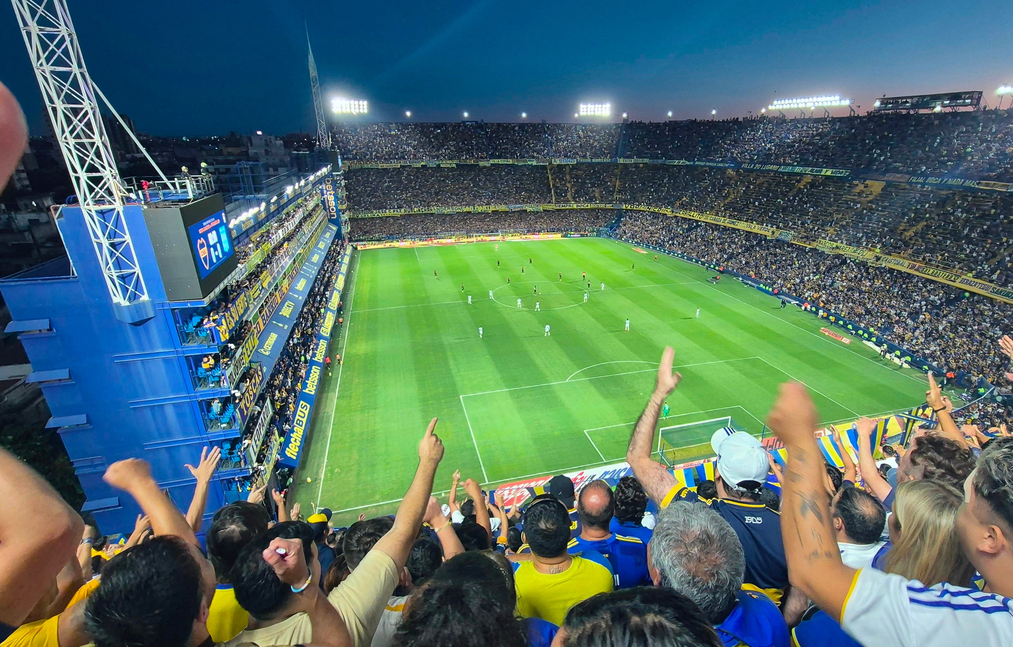 A packed, floodlit Argentine football stadium at night — the passion of football in Argentina